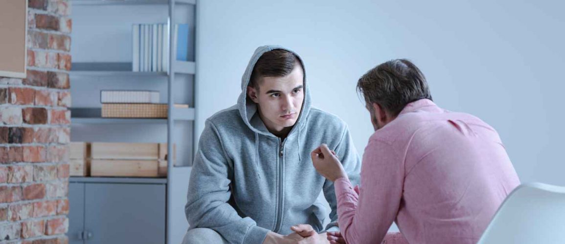 Breathe – Individual Case Management A psychology specialist explaining an action plan for recovery to a troubled teenage boy during an individual therapy session.